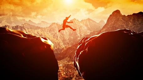 Daring Leap Across Mountain Cliffs wallpaper