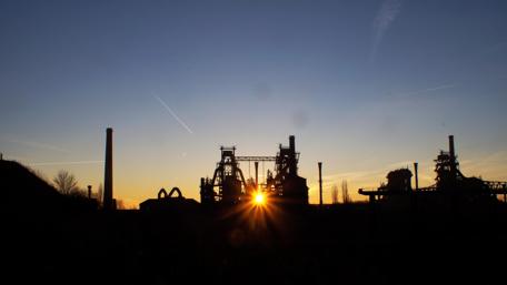 Industrial Sunrise Over Silhouetted Structures wallpaper