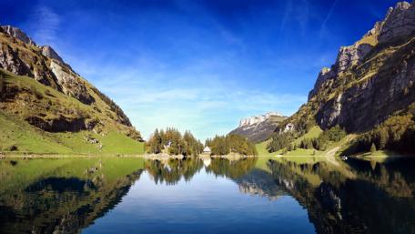 Sunlit Swiss River Reflection wallpaper