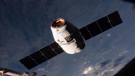 Majestic Dragon Spacescraft in Orbit Above Earth wallpaper