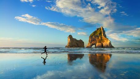 Energizing Beach Run Under Vibrant Sky wallpaper