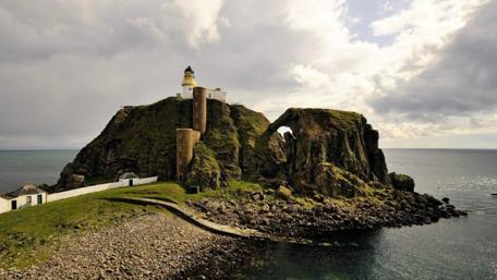 Scenic Lighthouse Overlooking the Ocean in Scotland wallpaper