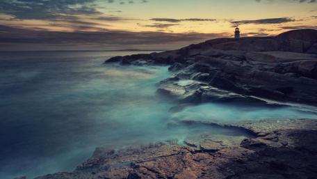 Rocky Shoreline Lighthouse at Dusk wallpaper