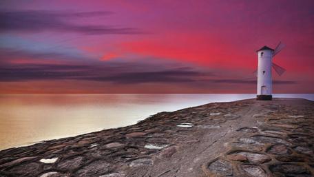 Lighthouse at Sunset Near the Sea Shore wallpaper