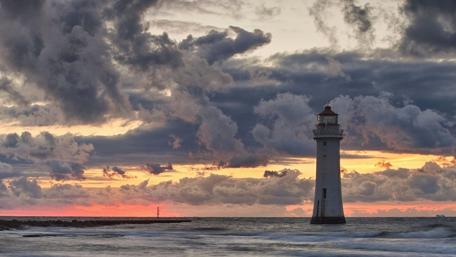 Lighthouse at Dusk with Dramatic Clouds wallpaper