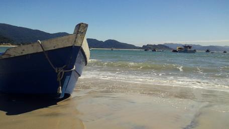 Serene Beach Scene with a Boat on the Shore wallpaper