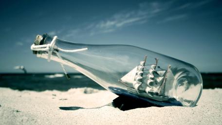 Schooner in a Bottle on Sandy Beach wallpaper