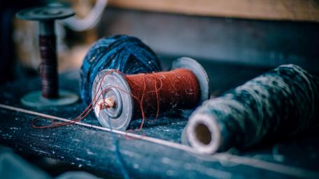 Colorful Yarn Balls and Spools on a Rustic Surface wallpaper