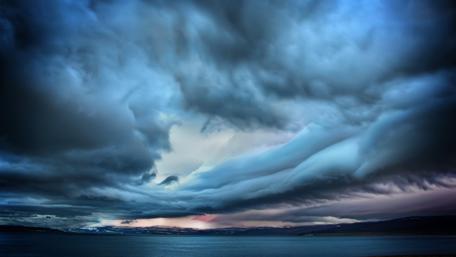 Dramatic Blue Storm Clouds Over Water wallpaper