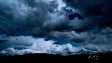 Dramatic Dark Clouds Above a Scenic Horizon wallpaper