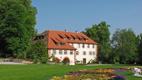 Elegant Mansion Surrounded by Lush Gardens and Flowers wallpaper