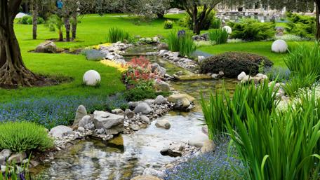 Tranquil Garden Stream in Vibrant Greenery wallpaper