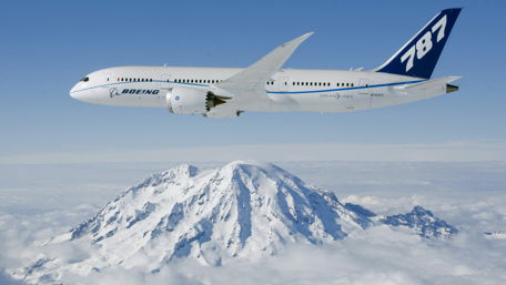 Boeing 787 Flying High Above Majestic Mountains wallpaper