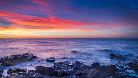 Vibrant Sunset Over the Stony Coastline wallpaper