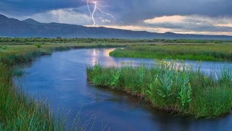 Dramatic Lightning over Serene River Landscape wallpaper