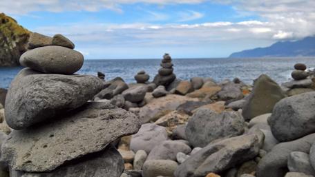 Serene Stone Stacking by the Ocean Waves wallpaper