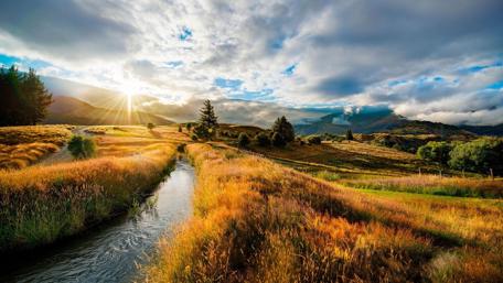 Sunrise Over Rolling Meadows and Serene Canal wallpaper