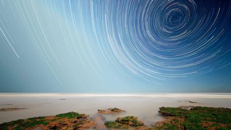 Star Trails Over Serene Seascape wallpaper