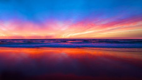 Breathtaking Sunrise Over Serene Seashore Reflection wallpaper