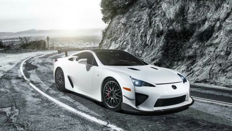 Sleek White Sports Car on a Scenic Rocky Road wallpaper