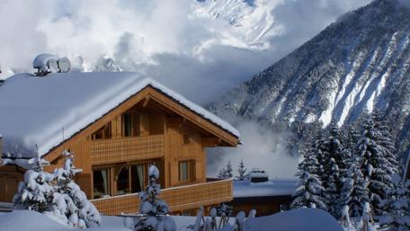 Winter Serenity in a Cozy Cottage Living Amidst Snowy Peaks and Pines wallpaper
