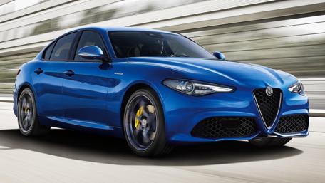 Dynamic Blue Alfa Romeo Giulia Veloce Driving Through Milan wallpaper