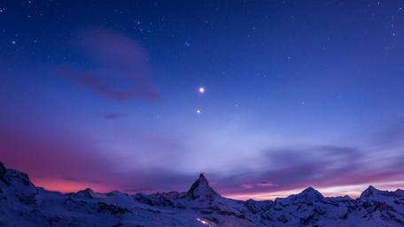 Majestic Starry Night Above Snowy Mountains wallpaper