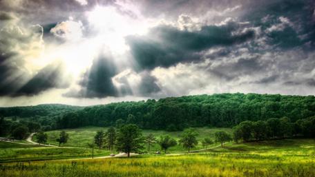 Majestic Sunrays Over Lush Hills wallpaper