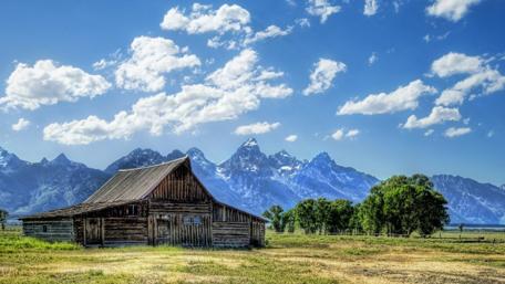Rustic Cottage Amidst Majestic Mountains wallpaper