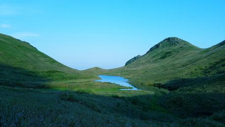 Serene Hillside Landscape with Reflective Lake wallpaper