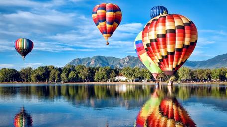 Balloons Lift Off Over Serene Lake wallpaper