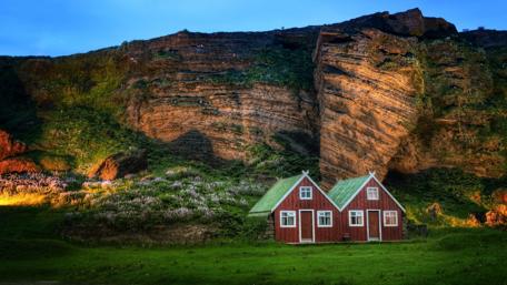Cozy Lodge Amidst Majestic Cliffs in Iceland wallpaper