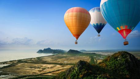 Hot Air Balloons Over Serene Landscape wallpaper
