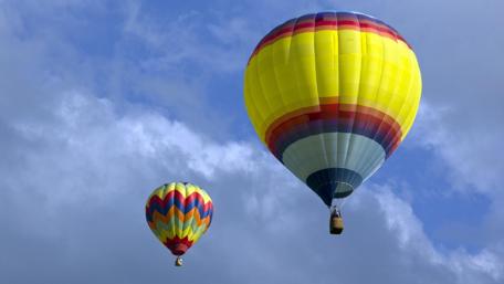 Colorful Hot Air Balloons in the Sky Above Clouds wallpaper