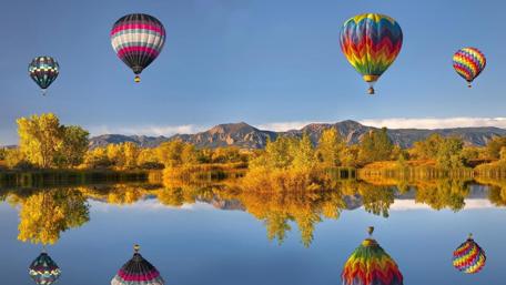 Vibrant Hot Air Balloons Over Calm Water wallpaper