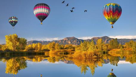 Vibrant Hot Air Balloons in Tranquil Landscape wallpaper