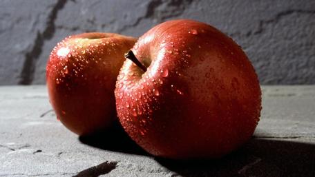 Fresh Red Apples with Dew Drops Shine Brightly on Stone Surface wallpaper