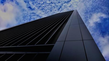 Skyscraper Reaching for the Sky Under Dramatic Clouds wallpaper