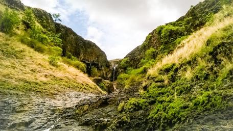 Majestic Waterfall Among Rugged Landscape wallpaper