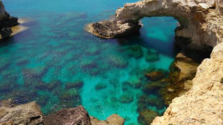 Cape Greco's Coastal Stone Arch wallpaper