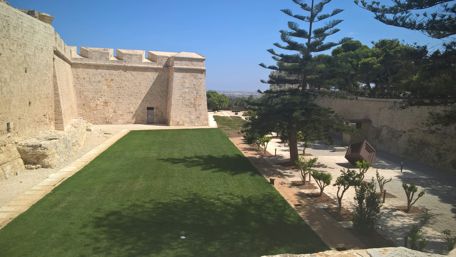 Mdina's Ancient Walls and Lush Greenscape wallpaper
