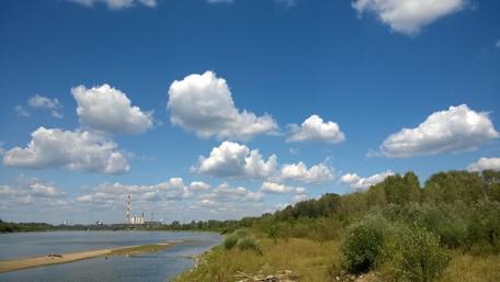 Serene River Under a Blue Sky with Fluffy Clouds wallpaper