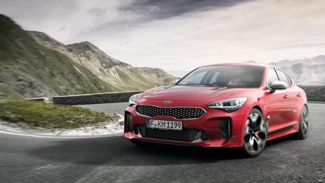 Dynamic Kia Driving Through Scenic Mountains wallpaper