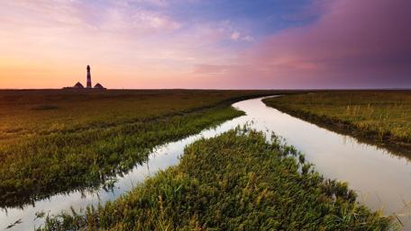Serene Sunset Over the Canal and Lighthouse wallpaper