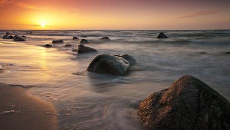 Serene Sunset Over Tranquil Seashore Stones wallpaper