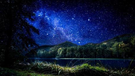 Starry Night Over Serene Lakeside Mountains wallpaper