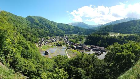 Serene Village Amidst Lush Mountainscapes wallpaper