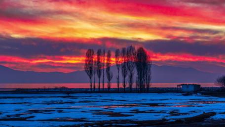 Fiery Sunset Over Snowy Landscape wallpaper