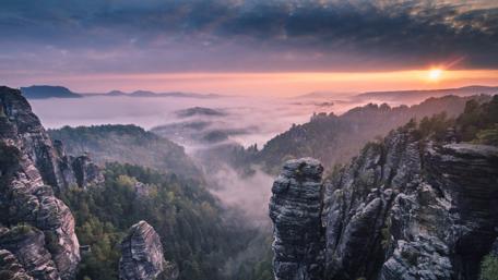 Serene Sunrise Over Mountainous Forests wallpaper