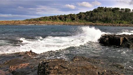 Serene Waves Crashing on Rocky Shoreline wallpaper